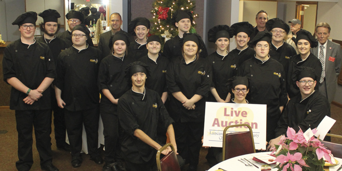 group of students wearing black chef jackets at a event